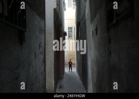 16 ottobre 2022, Città di Gaza, striscia di Gaza, Palestina: Una ragazza palestinese cammina di fronte alla sua casa nella parte settentrionale della striscia di Gaza, alti tassi di disoccupazione e mancanza di opportunità di lavoro a Gaza, il numero crescente di famiglie che devono affrontare la povertà dopo aver perso qualsiasi lavoro negli ultimi dieci anni del blocco di Gaza. (Credit Image: © Mahmoud Issa/Quds Net News via ZUMA Press Wire) Foto Stock