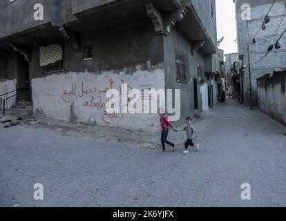 16 ottobre 2022, Città di Gaza, striscia di Gaza, Palestina: I bambini rifugiati palestinesi che camminano di fronte alla loro casa nella parte settentrionale della striscia di Gaza, gli alti tassi di disoccupazione e la mancanza di opportunità di lavoro a Gaza, e il crescente numero di famiglie che si trovano a dover affrontare la povertà dopo aver perso qualsiasi lavoro negli ultimi dieci anni del blocco di Gaza. (Credit Image: © Mahmoud Issa/Quds Net News via ZUMA Press Wire) Foto Stock