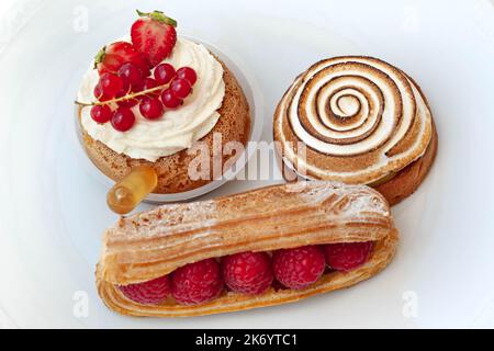 Tre deliziosi pasticcini su sfondo bianco Foto Stock