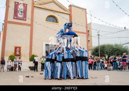 Acrobati dei Muixeranga di Alicante che esibiscono piramide umana fuori dalla chiesa di Parroquia de San Pedro Apóstol a Rojales, Spagna. Osservazione del pubblico Foto Stock