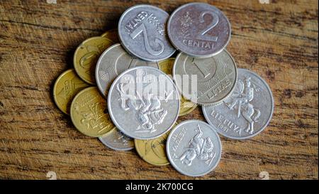 Varie vecchie monete lituane isolate su sfondo di legno Foto Stock