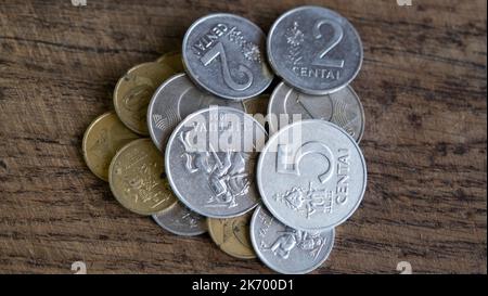 Varie vecchie monete lituane isolate su sfondo di legno. Foto Stock