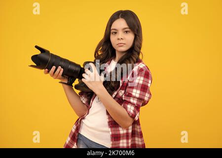 Hobby o carriera per i principianti del fotografo. Ragazza adolescente con macchina fotografica moderna che fa video e foto. I bambini usano la macchina fotografica digitale, fotografando. Foto Stock