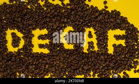 Iscrizione su chicchi di caffè decaffeinati, vista dall'alto del caffè. Foto Stock