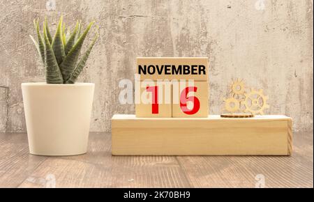 La mano maschile mette un blocco con l'iscrizione 'Happy Tolerance Day' su cubi con la data del 16 novembre. Bella tavola di legno, sfondo bianco, copia s Foto Stock