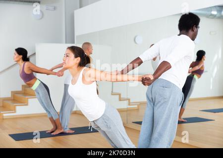 Lezioni di yoga per coppie nel moderno centro fitness Foto Stock
