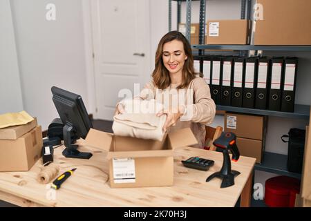 Giovane donna e-commerce di lavoro che prepara l'ordine in ufficio Foto Stock