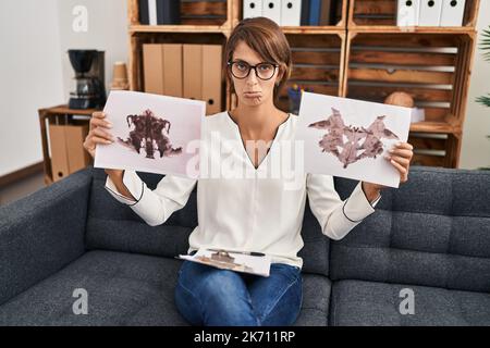 Donna brunette che lavora con rorschach test in psicologia clinica depresso e la preoccupazione per il disagio, piangendo arrabbiato e paura. espressione triste. Foto Stock