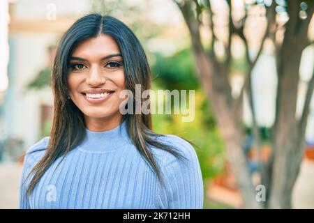 Bella donna ispanica sorridente confidente al parco Foto Stock