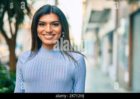 Bella donna ispanica sorridente confidente in città Foto Stock