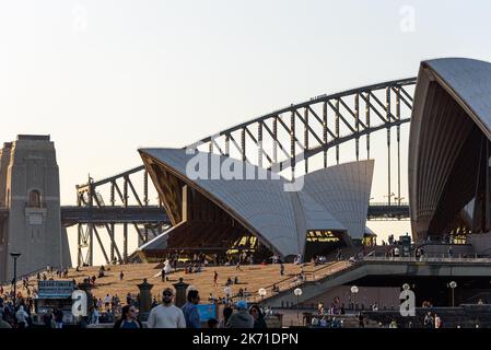 Persone che camminano di fronte all'Opera House di Sydney in una bella giornata di primavera Foto Stock