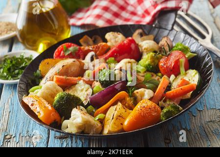 Da sopra padella con verdure grigliate assortite poste su un tavolo di legno shabby durante il pranzo Foto Stock