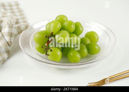 Brillare Moscato Verde uva giapponese su tavola bianca. Frutta fresca croccante e piccante Foto Stock