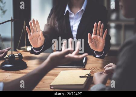 Uomini d'affari e avvocati che discutono di documenti contrattuali con scala di ottone su una scrivania di legno in ufficio. Diritto, servizi legali, consulenza, concetto di giustizia Foto Stock