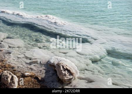 Sali minerali che si cristallizzano intorno a massi nella zona industriale stagno di evaporazione del Mar Morto vicino a Ein Bokek in Israele Foto Stock