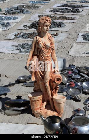 Una statua di una giovane ragazza venduta in un mercato delle pulci. La statua è in gesso. La statua è tra i vecchi oggetti metallici. Konya, Turchia. Foto Stock