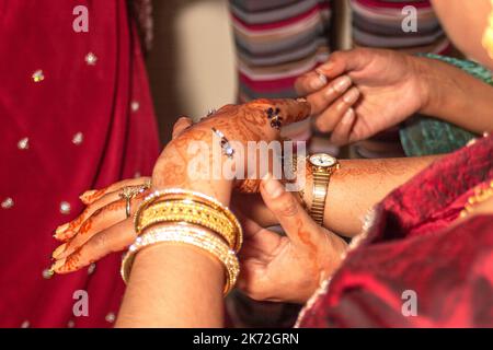 Sposa indiana che ha le sue decorazioni della pelle Mehndi applicato alla sua mano il suo giorno di nozze Foto Stock