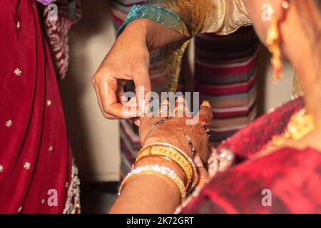 Sposa indiana che ha le sue decorazioni della pelle Mehndi applicato alla sua mano il suo giorno di nozze Foto Stock