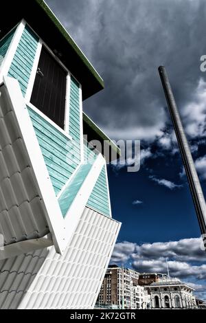 Casa capovolta sul lungomare di Brighton fotografata da un angolo basso a colori contro un cielo blu e nuvoloso Foto Stock