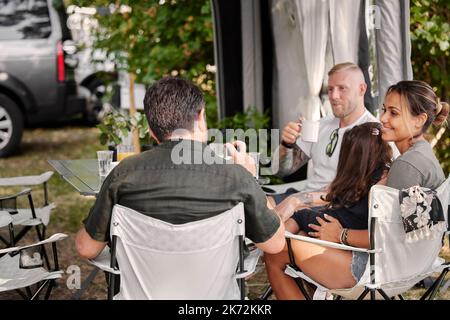 Amici con bambini che si rilassano sotto il gazebo giardino Foto Stock