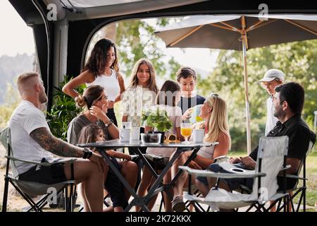 Amici con bambini che si rilassano sotto il gazebo giardino Foto Stock