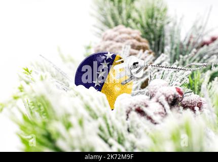 Sfondo colorato di Capodanno con una palla su cui è raffigurata la bandiera della Bosnia-Erzegovina. Il concetto di Capodanno e Natale. Foto Stock