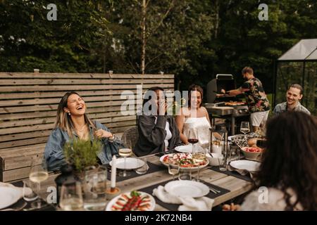 Friends having meal in garden Foto Stock