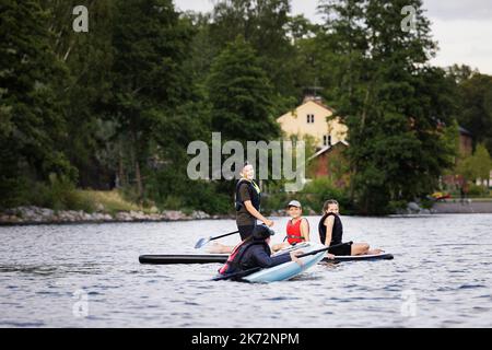 Madre e bambini paddle board sul lago Foto Stock