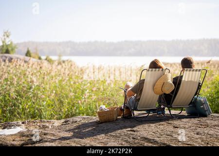 Coppia prendere il sole sulle sedie a sdraio Foto Stock