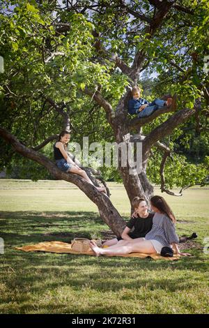 Madre con bambini che hanno picnic insieme Foto Stock