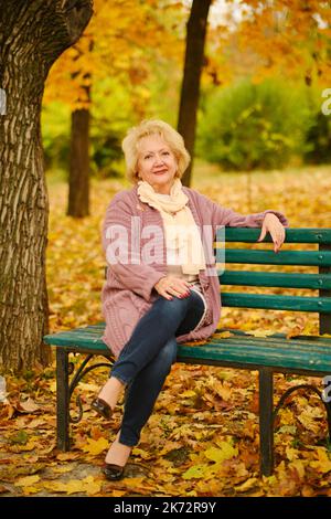 ritratto di nonna felice su una panchina del parco Foto Stock