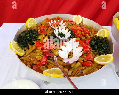 Okra stufato con pepe rosso, guarnito con limone, cipolla ed erbe aromatiche. Cibo nazionale turco Foto Stock