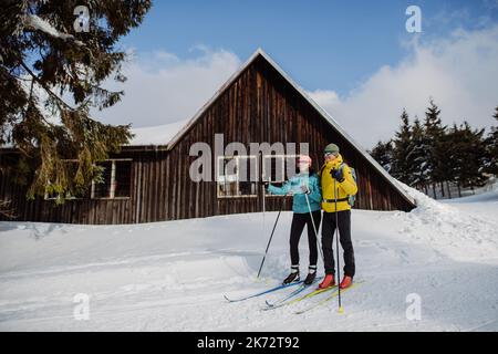 Coppia anziana in pausa durante lo sci, prossimo cottage foresta. Foto Stock