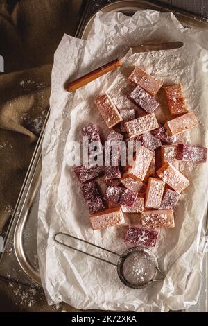 Caramelle di gelatina al gusto di frutta e frutti di bosco cosparse di zucchero a velo su vassoio di metallo Foto Stock