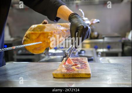 Chef irriconoscibile che serve jamon sul tagliere Foto Stock