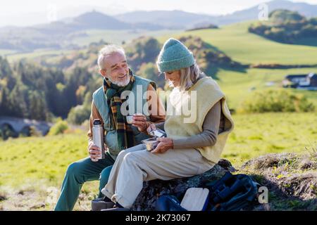 Coppia anziana in pausa durante le escursioni nella natura autunnale. Foto Stock