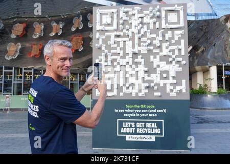 SOLO USO EDITORIALE Mark Foster utilizza un telefono cellulare per eseguire la scansione di un codice QR prodotto con materiali riciclati al di fuori della stazione di Birmingham New Street per contrassegnare l'inizio della settimana di riciclaggio 2022 di Recycle Now. Data immagine: Lunedì 17 ottobre 2022. Foto Stock