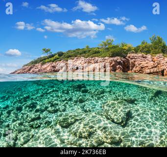 Split view - vista a metà sottomarina di splendidi fondali marini e costa rocciosa con pini, tacchino, Bodrum. Foto Stock