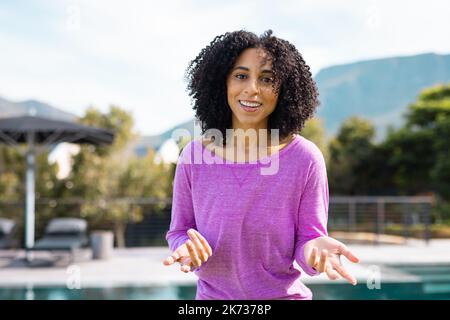 Ritratto di felice donna biraciale sorridente in giardino Foto Stock