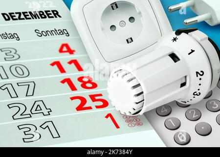 Calendario tedesco 2022 dicembre e termostato di riscaldamento con calcolatrice e presa di corrente Foto Stock