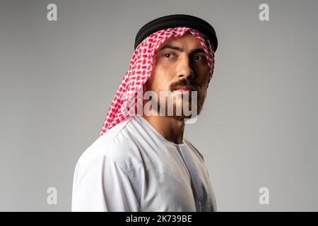 Ritratto del giovane arabo su sfondo grigio in studio Foto Stock