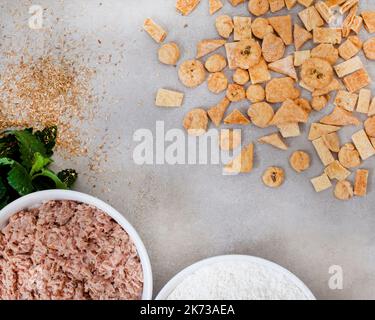 Speciale dolcetti di tonno fatti in casa su grigio chiazzato con ingredienti e spazio copia Foto Stock