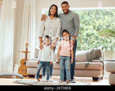 Un ciclo infinito di amore. Ritratto di una giovane famiglia che si unisce felicemente nel soggiorno di casa. Foto Stock