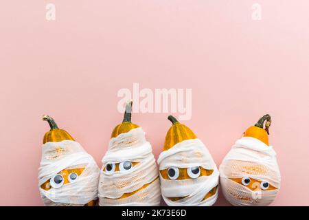 Hallowwen vacanza sfondo concetto. Zucche vestite come mummie spaventose con bende e occhi Foto Stock