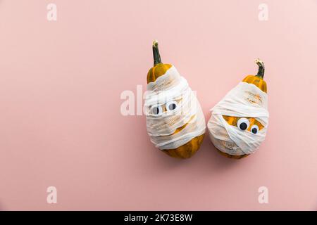 Hallowwen vacanza sfondo concetto. Zucche vestite come mummie spaventose con bende e occhi Foto Stock