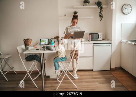 Mamma e i suoi figli in cucina Foto Stock