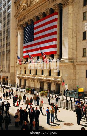 Una folla che si trova a pranzo cammina lungo Wall Street di fronte alla Borsa di New York, simbolo del potere economico americano, nel Financial District Foto Stock