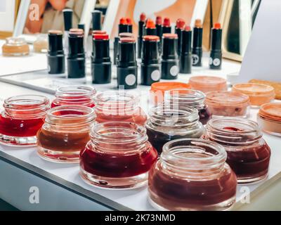 Cosmetici per il trucco prodotti di bellezza: Barattoli di tinta, polvere per il viso, rossetto closeup su marche locali negozio di mercato. Luce naturale, vista laterale Foto Stock