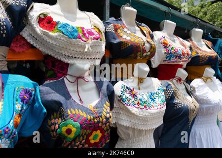 Abiti messicani ricamati sul mercato di strada stalla. Souvenir di abbigliamento femminile tradizionale fatto a mano a Guadalajara, Messico Foto Stock