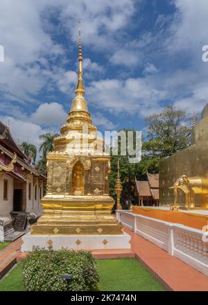 Splendida vista di piccoli stupa dorati con statua di Buddha in nicchia presso il famoso punto di riferimento Wat Phra Singh tempio buddista, Chiang mai, Thailandia Foto Stock